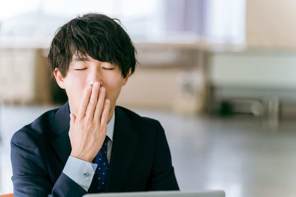 仕事が暇であくびする男性