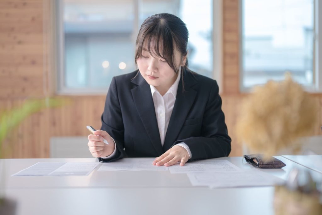 入社書類で家族構成を書く女性