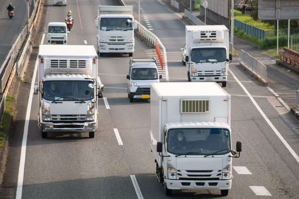 高速道路を走行するトラックの群れ